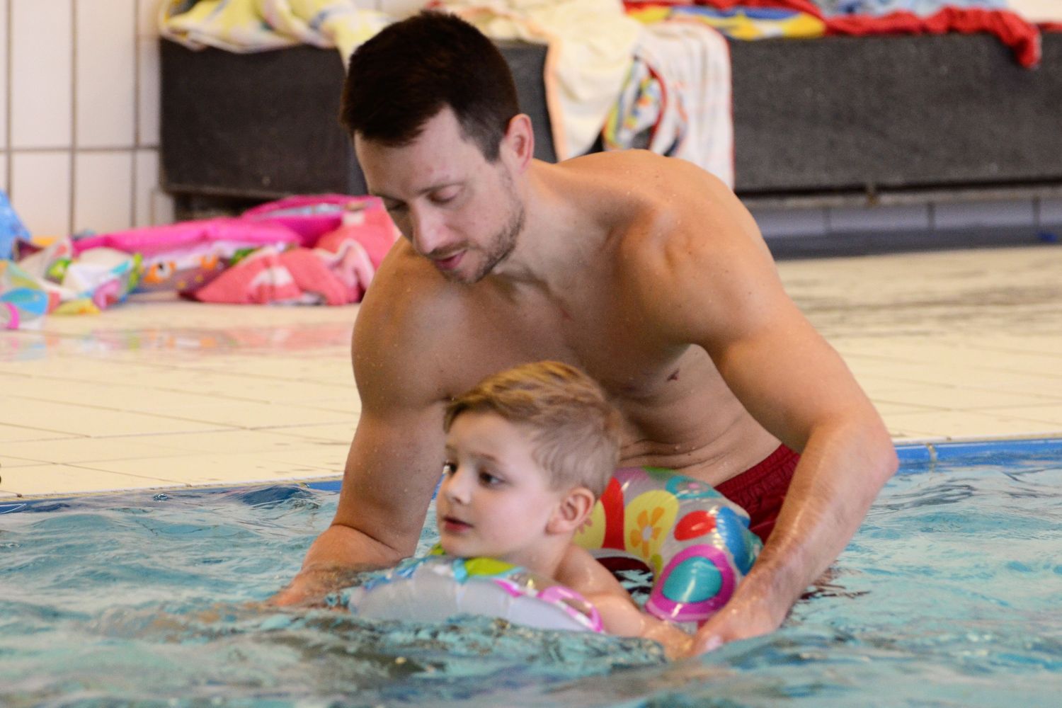 Marco Baldauf übt mit einem Buben im Wasser